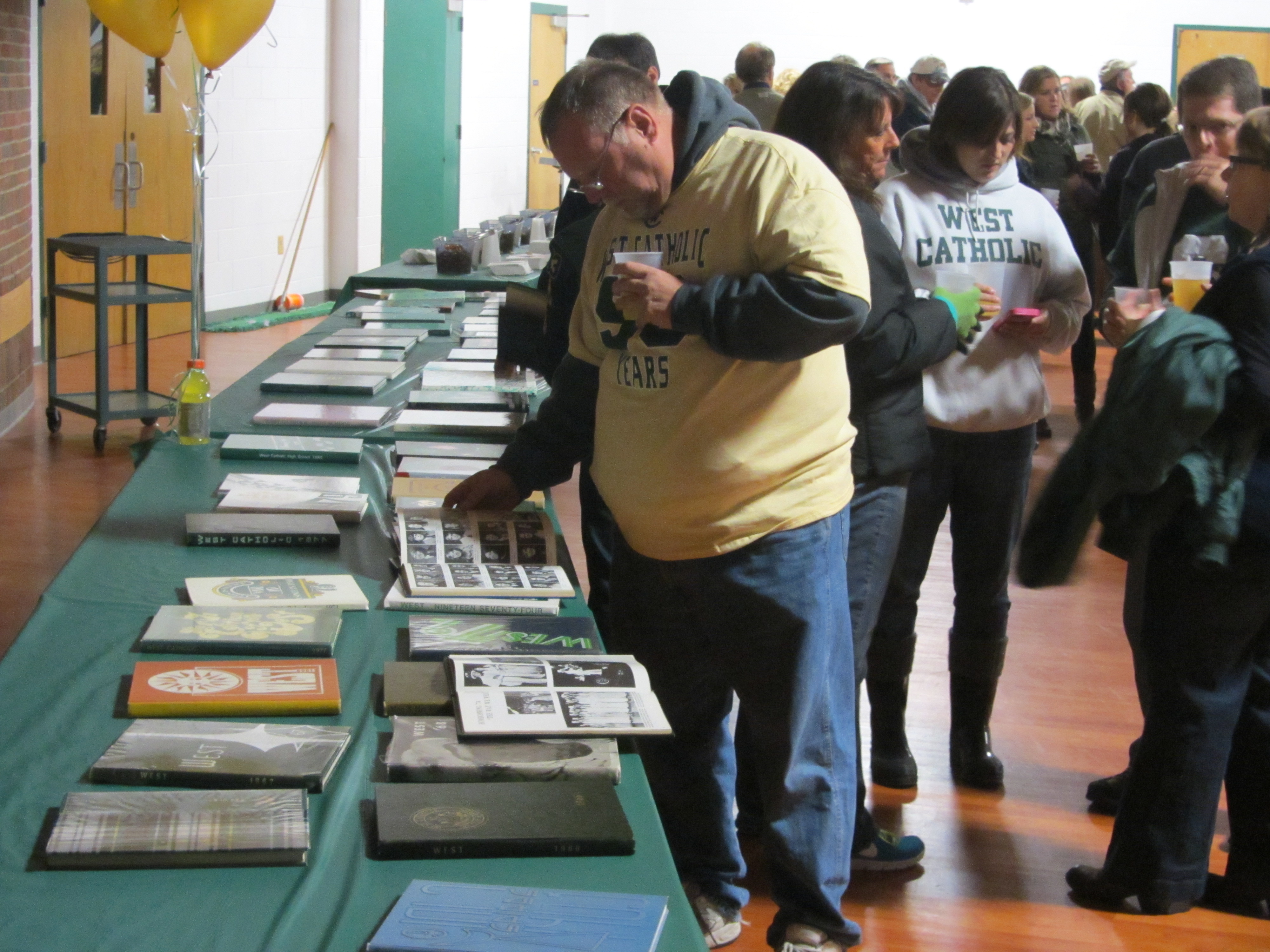Perusing yearbooks at the all-alumni 50th Anniversary Homecoming 5th Quarter party